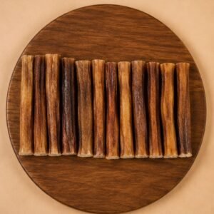 Row of brown cinnamon sticks lined up on a round wooden board.